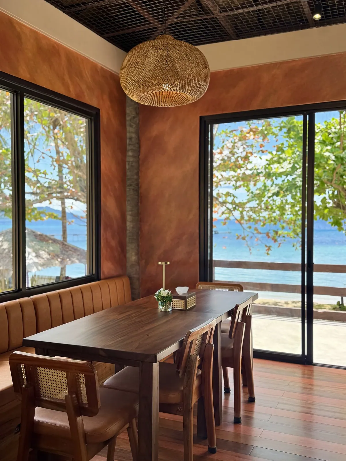 SANA dining table with terracotta walls and a full sea view